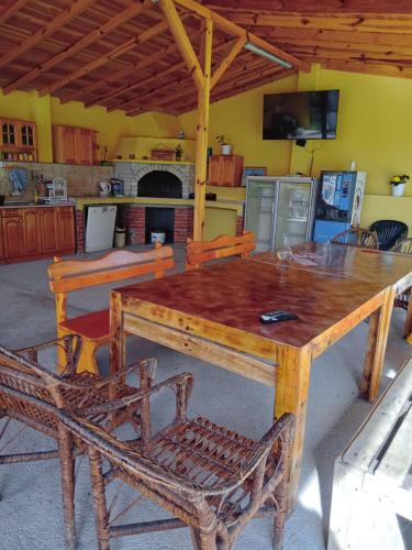 a wooden table with two chairs and a kitchen at Вила Сириус in Sinemorets