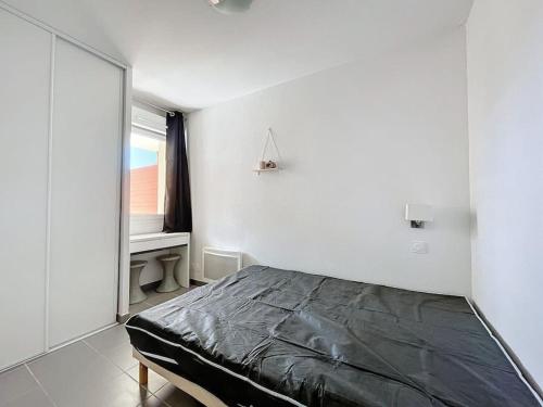 a bedroom with a bed and a window and a desk at 3284 - appartement 4 couchages avec piscine in Argelès-sur-Mer