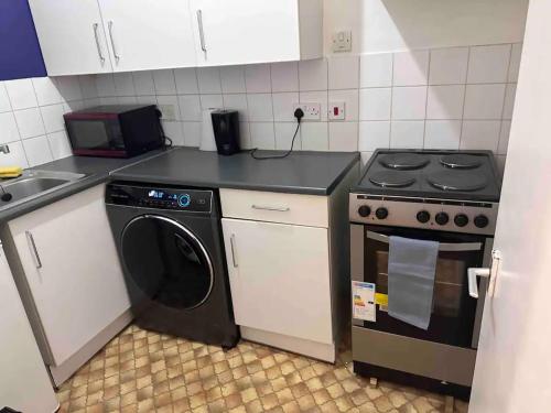 y cocina con fogones y lavadora. en Charming 1-Bed Apartment in London, en Londres