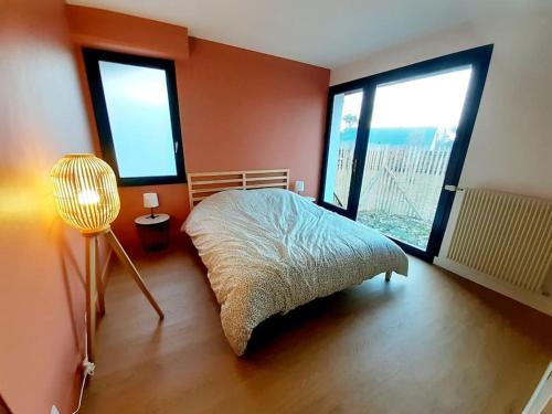 une chambre avec un lit et deux grandes fenêtres dans l'établissement Le cottage, 2 à 8 personnes, 14kms de Blois, à Monthou-sur-Bièvre