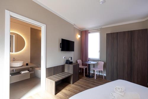 a hotel room with a bed and a bathroom at Le Fare in Fara Novarese