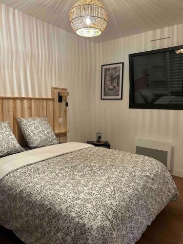 une chambre avec un grand lit et une télévision à écran plat dans l'établissement Gîte neuf en ossature bois à 5 minutes de Berck., à Verton