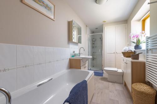 ein Badezimmer mit einer Badewanne, einem WC und einem Waschbecken in der Unterkunft The Tallet at Accott Manor 