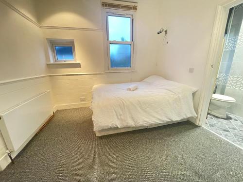 a small bedroom with a bed and a bathroom at Room with private bathroom and shared kitchen in London
