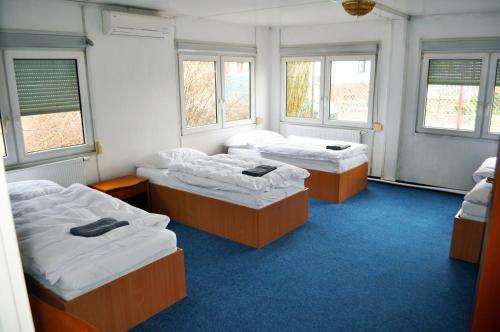 three beds in a room with three windows at Lotos in Karlovy Vary