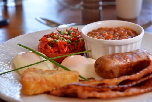 a plate of food with eggs and meat and sauce at Pumula Beach Hotel in Umzumbe
