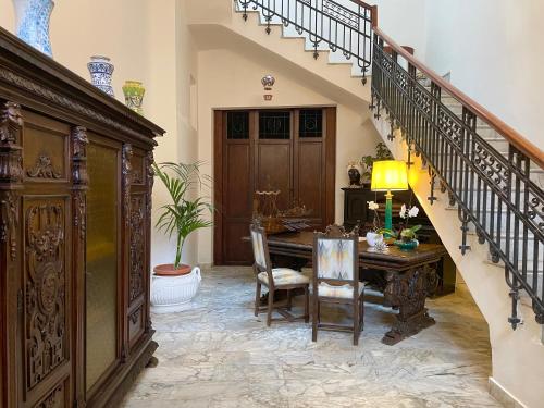 a dining room with a table and a staircase at DOMUS ALERIA Deluxe Rooms in Sciacca