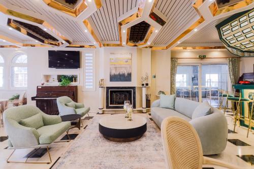 a living room with a couch and chairs and a fireplace at Hotel Strass in Paralia Katerinis