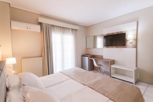a hotel room with a bed and a desk at Hotel Strass in Paralia Katerinis