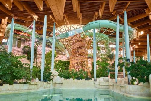 - un toboggan dans un bâtiment avec piscine dans l'établissement Disney Horizon Parc Studio 5 personnes PK privé gratuit balcon lit bébé, à Montévrain