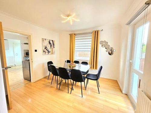 a dining room with a glass table and black chairs at 3 Bed House with 6 Beds by Sensational Stay in Edinburgh
