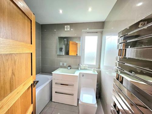 ein Badezimmer mit einem Waschbecken, einem WC und einer Badewanne in der Unterkunft 3 Bed House with 6 Beds by Sensational Stay in Edinburgh