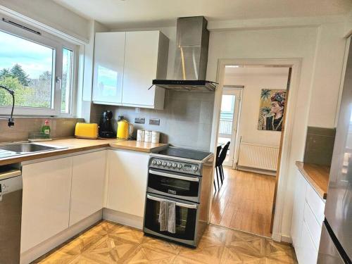 a kitchen with white cabinets and a stove top oven at 3 Bed House with 6 Beds by Sensational Stay in Edinburgh