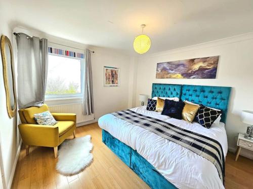 ein Schlafzimmer mit einem blauen Bett und einem gelben Stuhl in der Unterkunft 3 Bed House with 6 Beds by Sensational Stay in Edinburgh