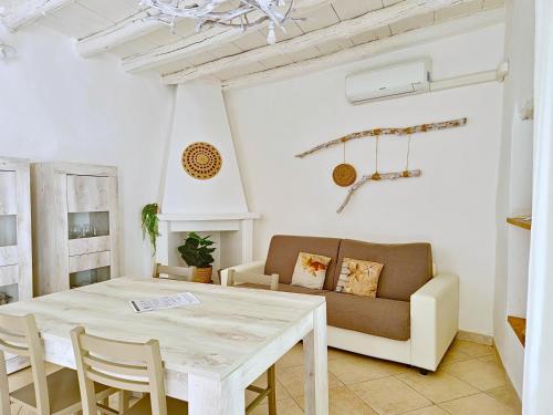 a living room with a table and a couch at Le Arcada - Appartamenti nel cuore del centro storico di Orosei in Orosei