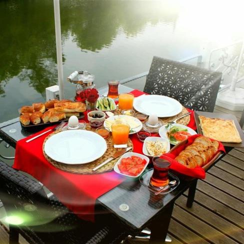 una mesa con comida y bebidas en una mesa cerca del agua en 216 North Hotel, en Agva
