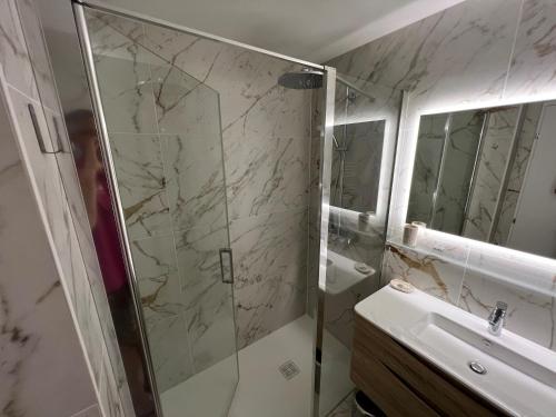 une salle de bain avec douche et lavabo dans l'établissement Appart 2P Vue Mer Panoramique Cannes Eden, à Vallauris