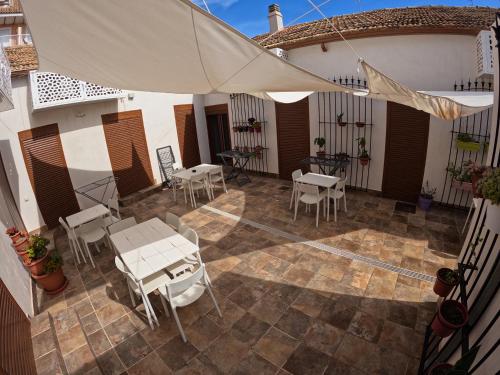 an outdoor patio with tables and chairs and an umbrella at Apartamentos La Encarnación III in Los Alcázares