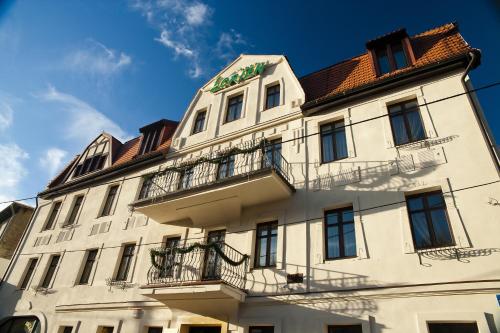 a white building with balconies on the side of it at Pensjonat Lorien in Szczawno-Zdrój