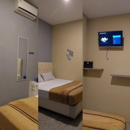 Habitación de hotel con 2 camas y TV en Deluxe Suite And Room, en Sidoarjo