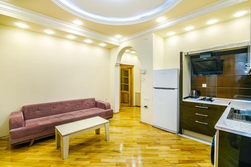 a living room with a couch and a kitchen at Boulvard M Estate in Baku