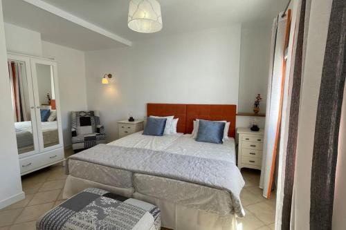 a bedroom with a large bed with blue pillows at Casa Azahar luxury two bedroom top floor apartment in Alhaurín el Grande
