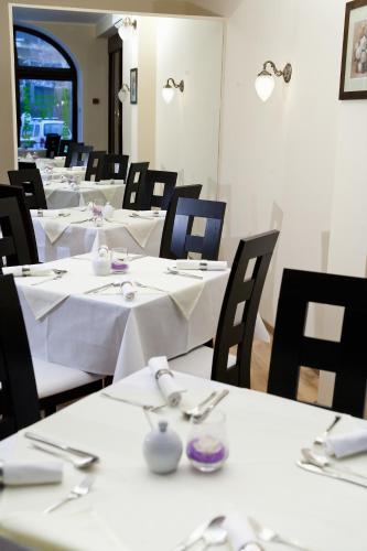 a dining room with white tables and black chairs at Pensjonat Lorien in Szczawno-Zdrój