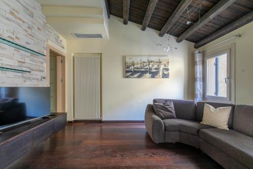 - un salon avec un canapé et une télévision dans l'établissement Ca' Balin - Chioggia, à Chioggia