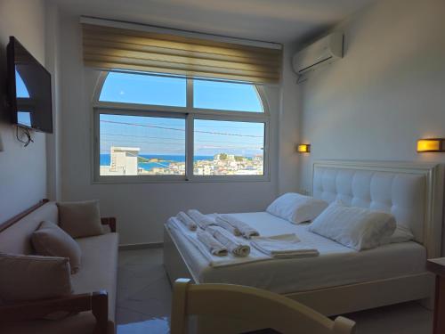 a bedroom with a bed and a large window at Villa A & A in Ksamil
