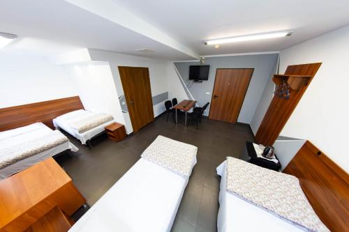 カトヴィツェにあるTwój Hostel Klimczoka 7のベッド2台とテレビが備わるホテルルームです。