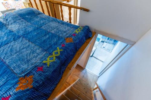 uma cama com um edredão azul num quarto em Casa Musio em Cagliari