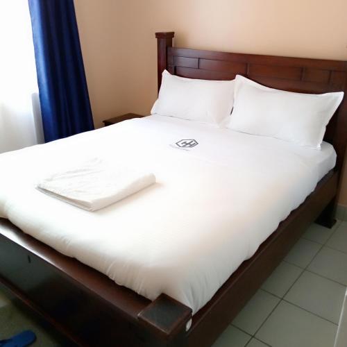 1 cama con ordenador portátil encima en New Carnation Pangani Hotel, en Nairobi