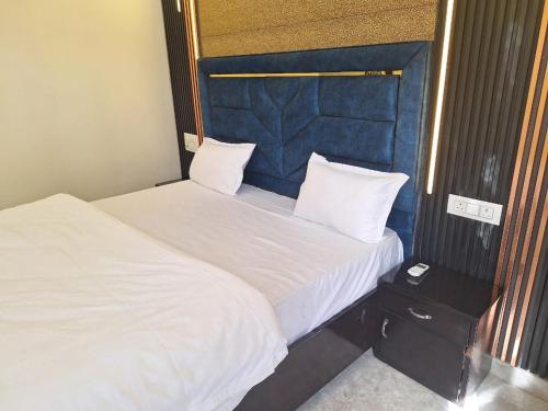 2 Betten mit weißer Bettwäsche und Kissen in einem Zimmer in der Unterkunft Shivraat Hotel Rishikesh in Rishikesh
