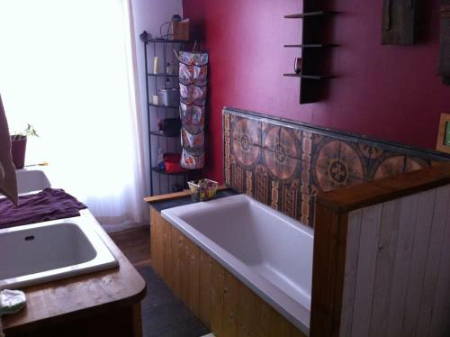 uma casa de banho com uma banheira e um lavatório em Maison d'artistes jolie et atypique em Vivonne