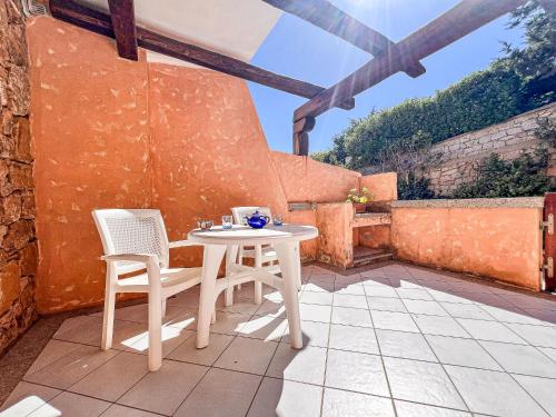 a white table and two chairs on a patio at Cala Reale 101 in Capo Testa