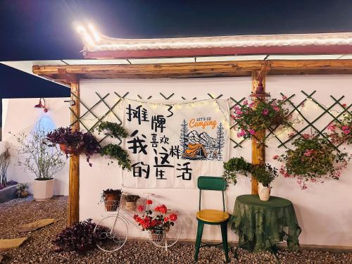 eine weiße Wand mit einem Schreibtisch und Stühlen in der Unterkunft Lijiang Hengchang Baoyin Mohuakai Inn in Lijiang