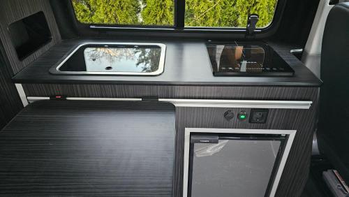 un interior de una caravana con una mesa y una ventana en Flow Campervan, en Radomlje