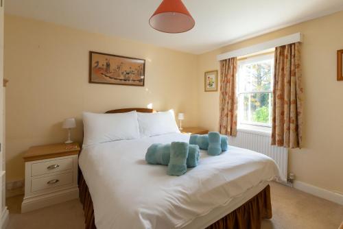 a bedroom with a bed with two teddy bears on it at Upper Instow Beach Cottage in Instow