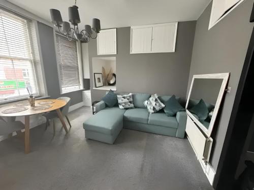 a living room with a blue couch and a table at 1-Bedroom Flat in Islington! in London