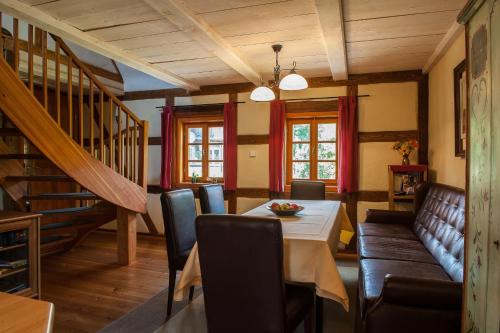 una sala da pranzo con tavolo, sedie e scala di Ferienhaus zum Rundling a Pirna