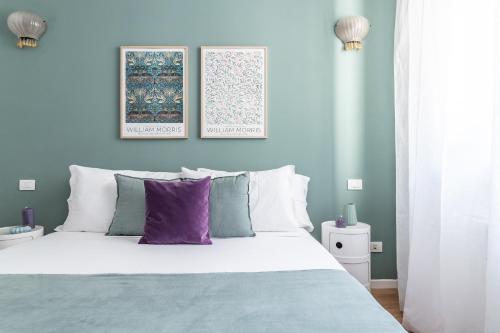 een slaapkamer met een groot wit bed met paarse kussens bij Design suite con terrazza in via Masera 6 in Milaan