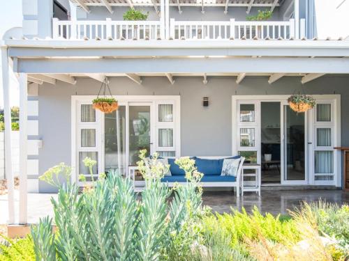 a house with a blue couch on a patio at La Dolce Vita Gordon’s Bay in Gordonʼs Bay
