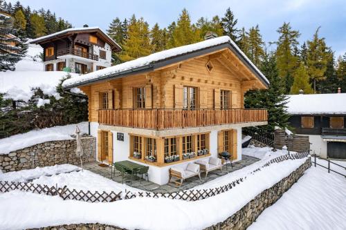 a log home in the snow with snow covered ground at Chalet Onni in La Tzoumaz