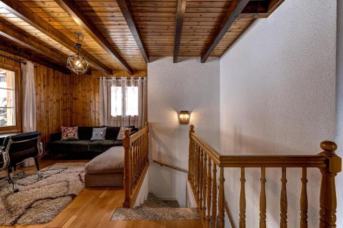 a living room with a staircase and a couch at Chalet Onni in La Tzoumaz