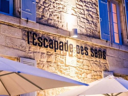 a sign on the side of a building with two umbrellas at Hôtel de France et de Russie in Thiviers