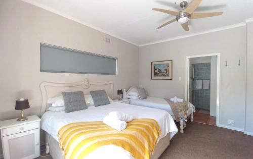 a bedroom with two beds and a ceiling fan at Koo Karoo Guest Lodge and Self Catering in Montagu