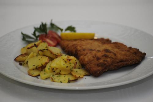 a plate of food with fish and potatoes on it at Sturmhof in Chiusa