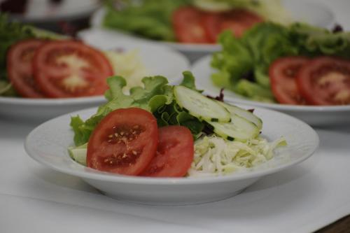 a plate of salad with tomatoes and lettuce on a table at Sturmhof in Chiusa