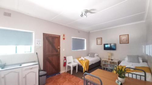 a small room with two beds and a table at Koo Karoo Guest Lodge and Self Catering in Montagu