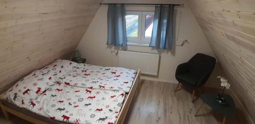 a small bedroom with a bed and a window at Chalet Maria HOT TUBE SAUNA in Loučná pod Klínovcem
